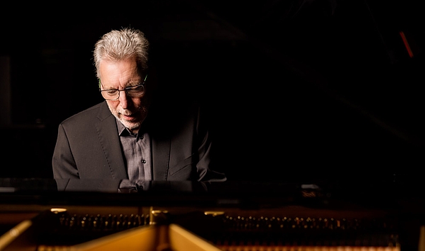 The picture shows a man at the grand piano. Das Bild zeigt einen Mann am Konzertflügel.