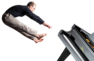 The picture shows a man hovering over a concert grand piano. 
