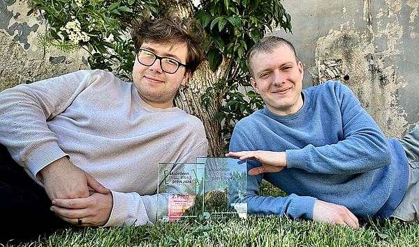 Das Bild zeigt zwei junge Männer mit gläsernen Trophäen. Das Bild zeigt zwei junge Männer mit gläsernen Trophäen.