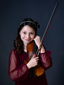 The picture shows a young person with a violin.