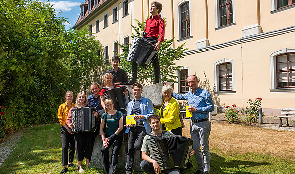 Das Bild zeigt junge Musiker mit Akkordeonen im Garten des Fürstenhauses.