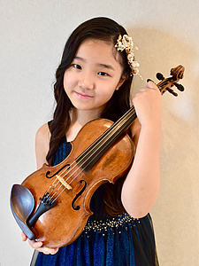 The picture shows a child with a violin.
