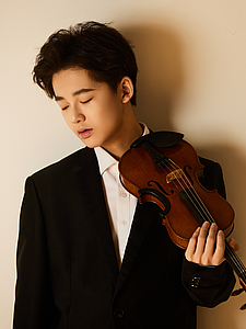 The picture shows a young person with a violin.