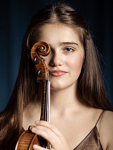 The picture shows a young person with a violin.