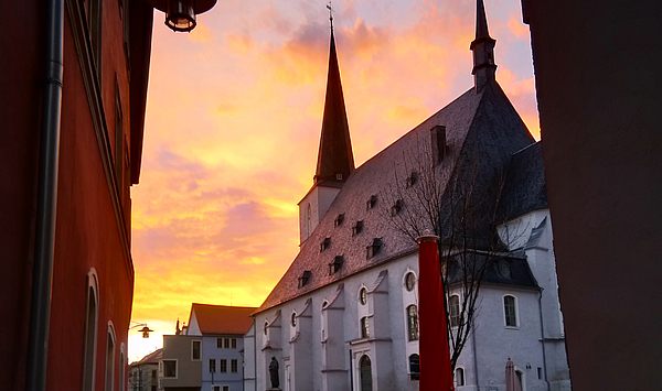 Das Bild zeigt eine Kirche in der Abenddämmerung.