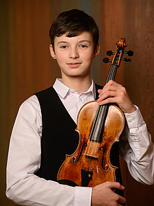 The picture shows a young person with a violin.