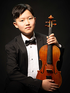 The picture shows a child with a violin.