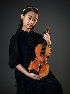 The picture shows a young person with a violin.