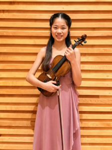 The picture shows a young person with a violin.