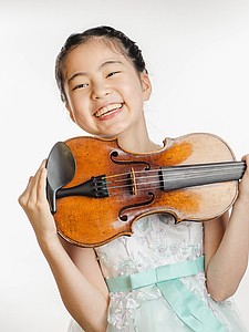 The picture shows a young person with a violin.