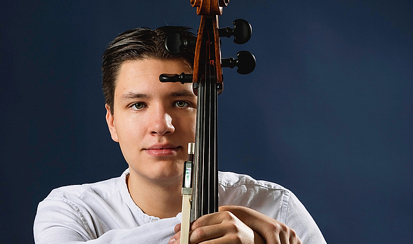 Das Bild zeigt einen Mann mit einem Cello.