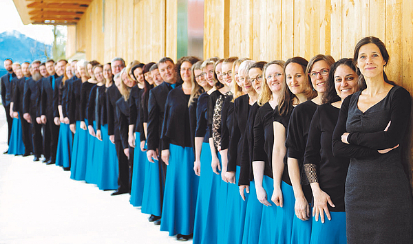 The picture shows a choir in blue and black clothes. Das Bild zeigt einen Chor in blauer und schwarzer Kleidung.