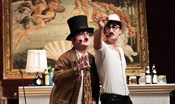 In the picture you can see two young men with hats and glued noses. Auf dem Bild sieht man zwei junge Männer mit Hüten und angeklebten Nasen.