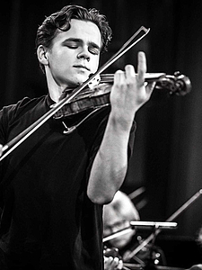 The picture shows a young person with a violin.