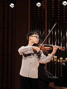 The picture shows a child with a violin.
