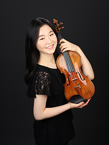 The picture shows a young person with a violin.