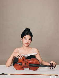 The picture shows a young person with a violin.
