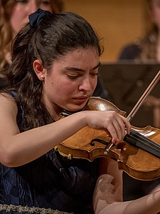 The picture shows a young person with a violin.