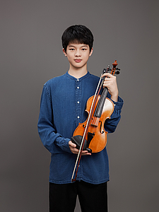 The picture shows a young person with a violin.