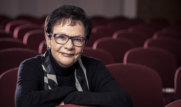 Das Bild zeigt eine Frau in einem Konzertsaal.