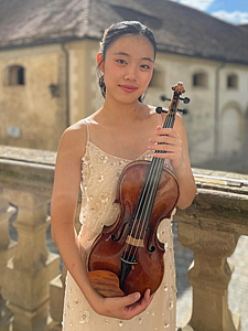 The picture shows a young person with a violin.