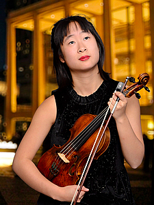 The picture shows a young person with a violin.