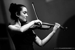 Young girl standing on stage with her violin.