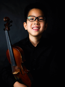 The picture shows a child with a violin.