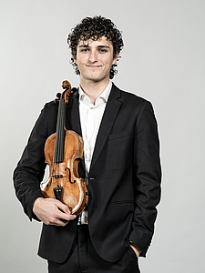 The picture shows a young person with a violin.