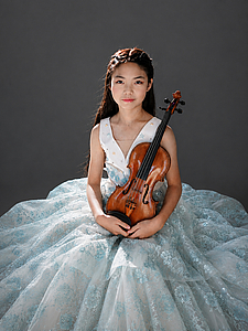 The picture shows a child with a violin.