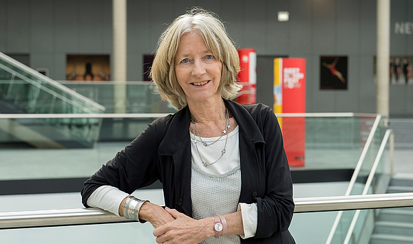 Das Bild zeigt eine Frau in einem Foyer.