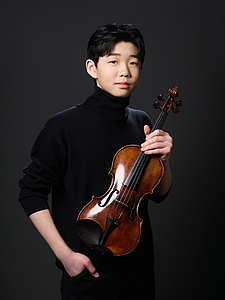 The picture shows a young person with a violin.