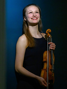 The picture shows a young person with a violin.