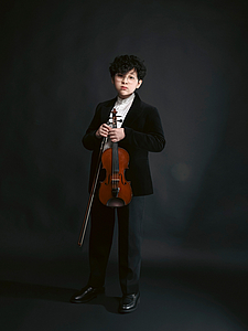 The picture shows a child with a violin.