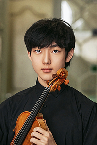 The picture shows a young person with a violin.