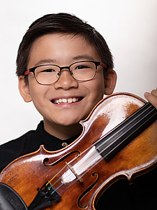 The picture shows a child with a violin.