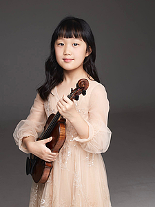 The picture shows a child with a violin.