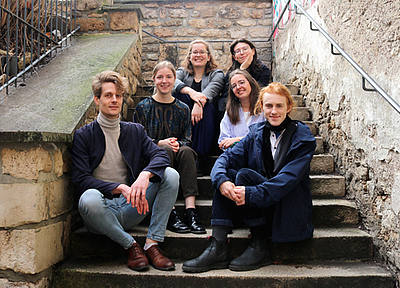 The picture shows a group of young people on a staircase. 