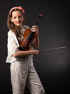 The picture shows a young person with a violin.