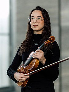 The picture shows a young person with a violin.
