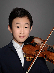 The picture shows a young person with a violin.