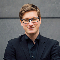 Portrait of a young man with glasses in black clothes