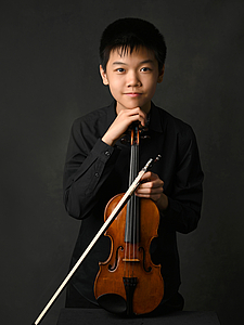 The picture shows a child with a violin.