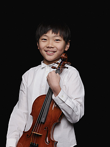 The picture shows a child with a violin.