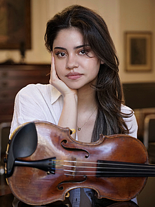 The picture shows a young person with a violin.