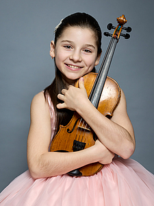 The picture shows a child with a violin.