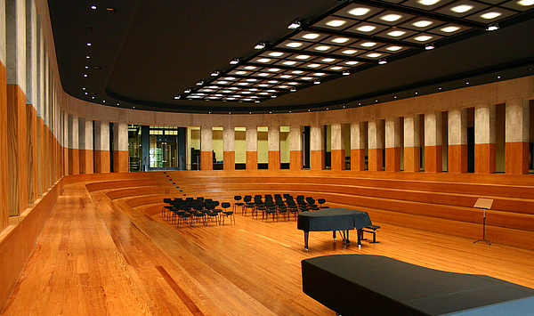 The picture shows a large hall with a concert grand piano. Das Bild zeigt einen großen Saal mit einem Konzertflügel.