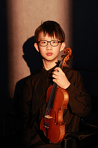 The picture shows a child with a violin.