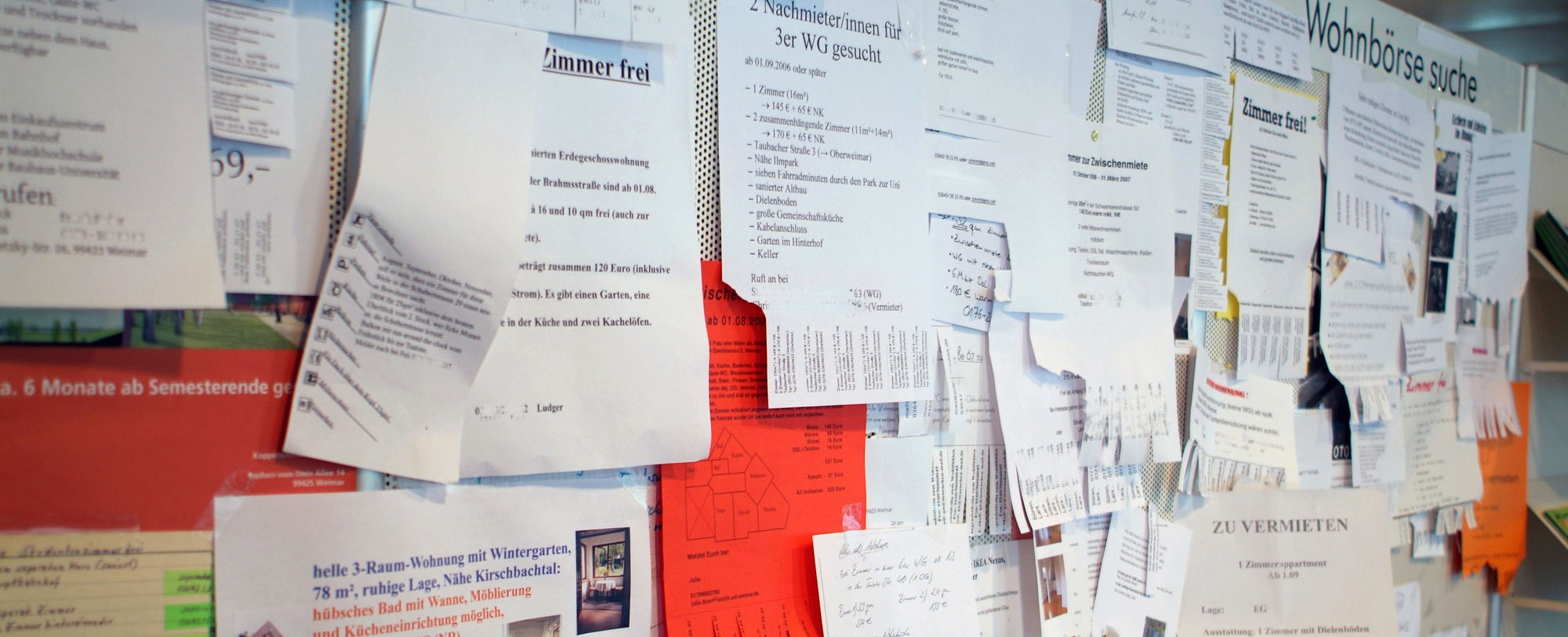 The picture shows slips of paper hanging on a bulletin board.