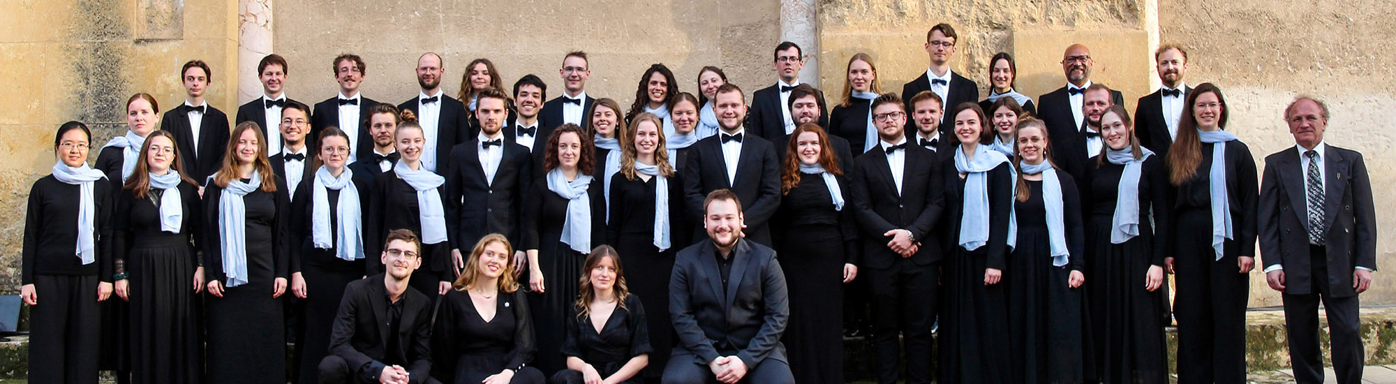 Das Bild zeigt Menschen vor einer Mauer.